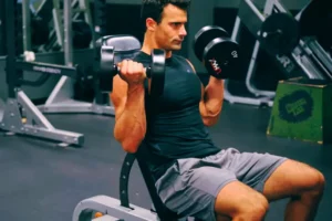 a man lifting weights doing Dumbbell Seated Curl